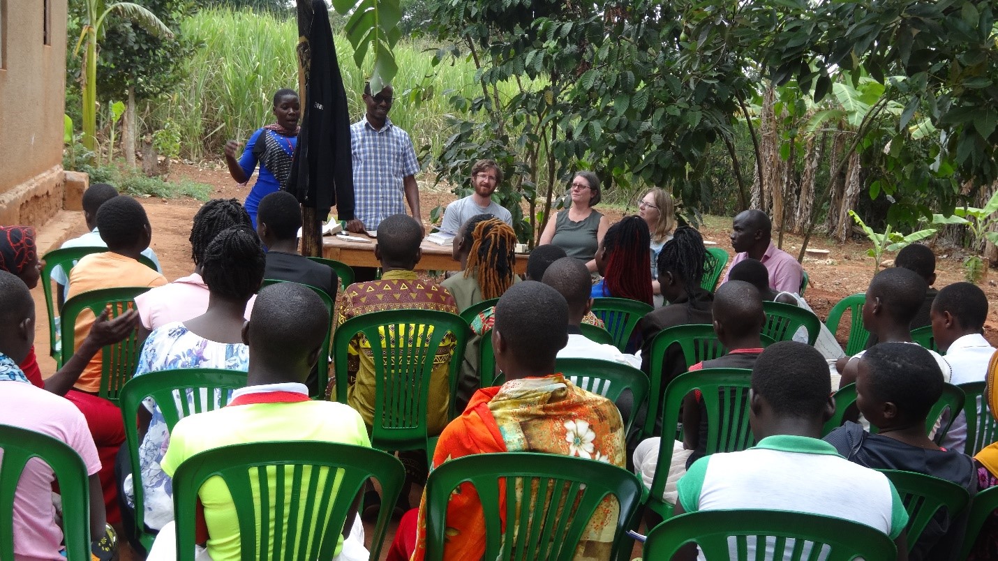 Elizabeth one of the MCEC girl standing with Pastor Samuel giving remarks to girls in presence of visitors from USA